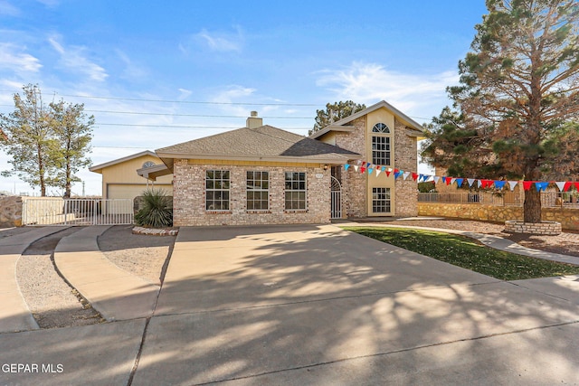 view of front facade featuring concrete driveway, brick siding, and fence