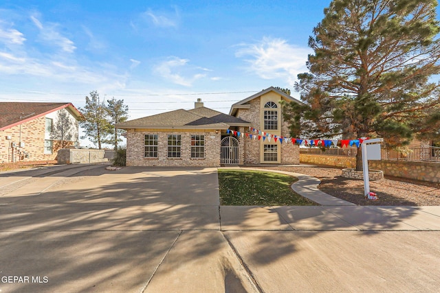 view of front of house with a fenced front yard, a chimney, and a gate