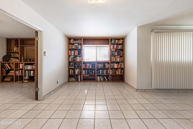 3405 Volcanic Ave, El Paso, TX 79904 - empty room with built in shelves, light tile patterned floors, and baseboards
