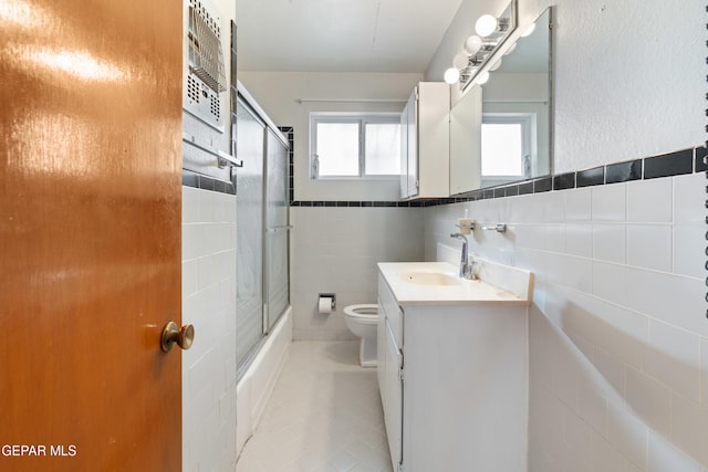 full bathroom featuring tile walls, a healthy amount of sunlight, and tile patterned floors