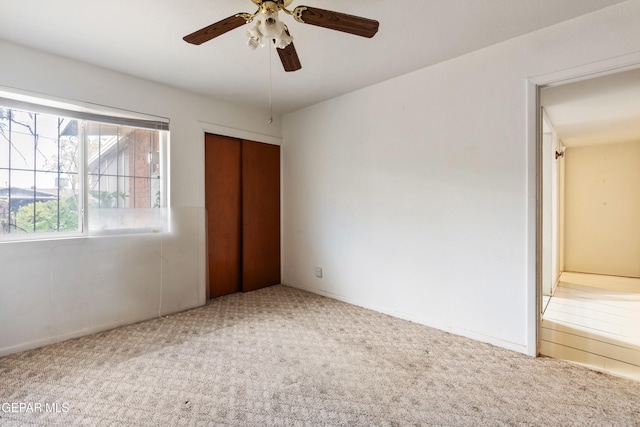 unfurnished bedroom with ceiling fan, a closet, and carpet