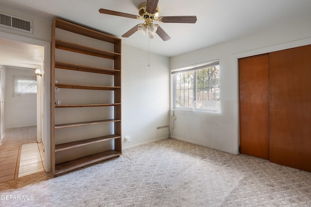 unfurnished bedroom with a closet, light carpet, and ceiling fan