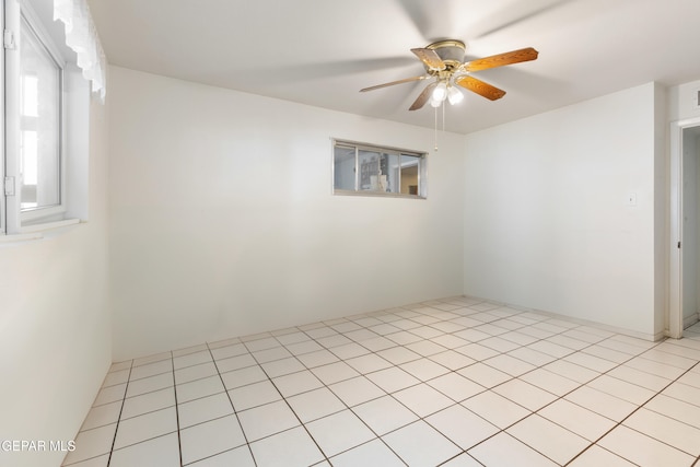 empty room with light tile patterned floors and ceiling fan