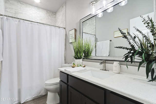 bathroom with toilet, a shower with curtain, vanity, and hardwood / wood-style floors