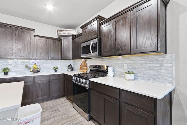 kitchen featuring stainless steel appliances, light hardwood / wood-style floors, dark brown cabinetry, and tasteful backsplash