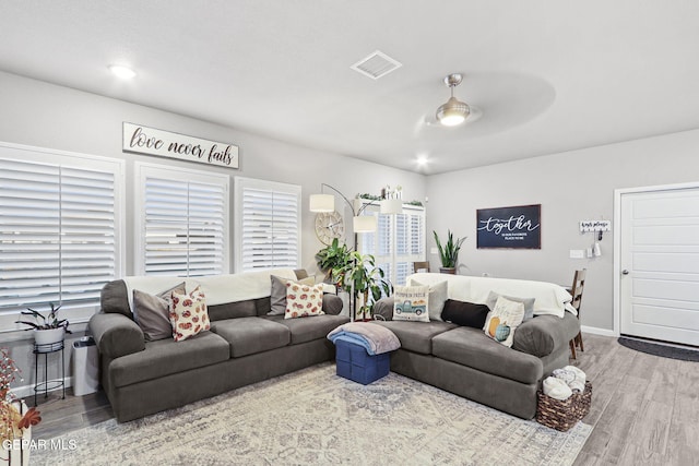 living room featuring ceiling fan and light hardwood / wood-style flooring