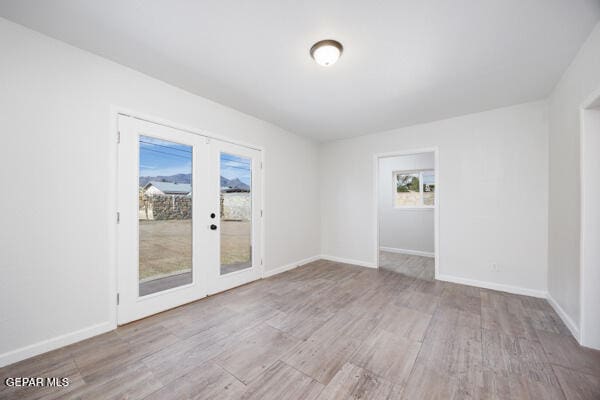 unfurnished room featuring light wood-type flooring and french doors