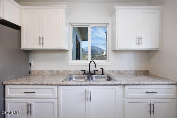 kitchen featuring white cabinets and sink