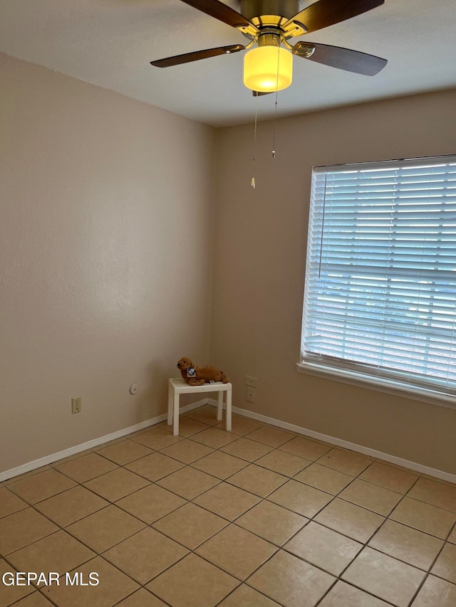 spare room with light tile patterned floors and ceiling fan