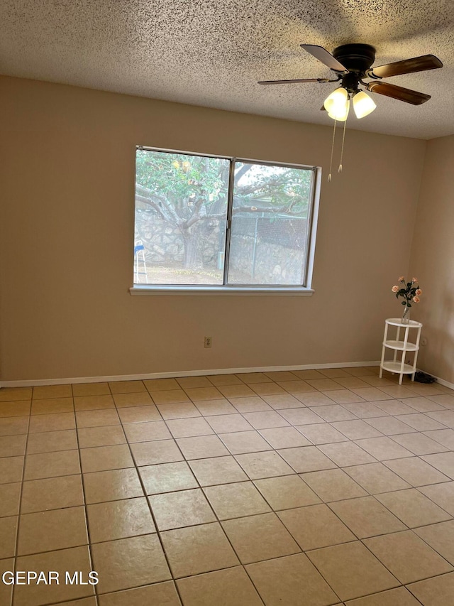 unfurnished room featuring plenty of natural light, light tile patterned floors, and a textured ceiling