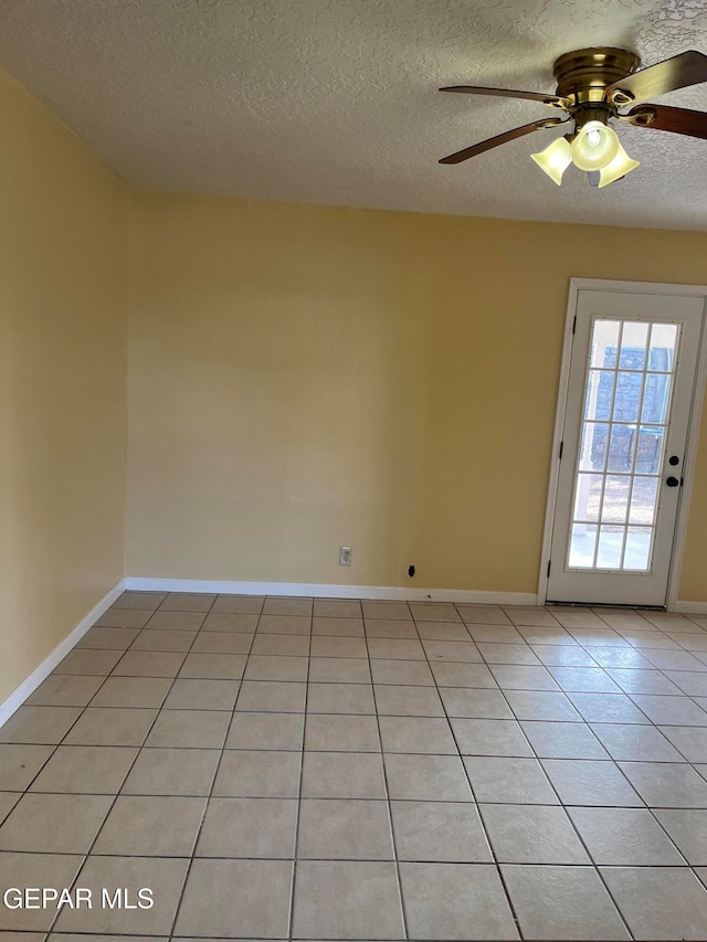 tiled empty room featuring a textured ceiling and ceiling fan