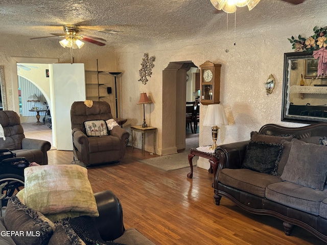 living room featuring hardwood / wood-style floors, a textured ceiling, and ceiling fan