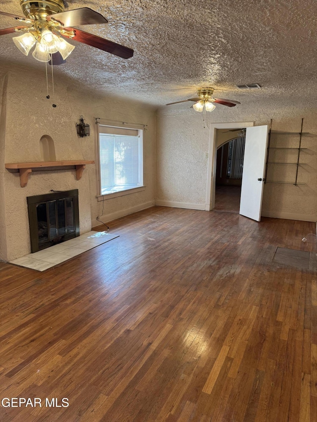 unfurnished living room featuring wood-type flooring, a textured ceiling, and ceiling fan