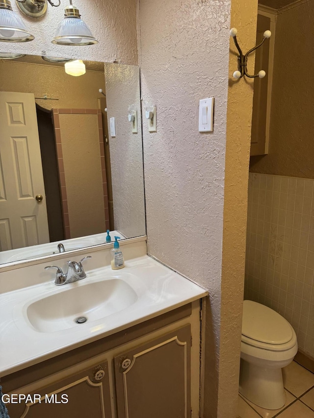 bathroom featuring tile patterned flooring, vanity, and toilet