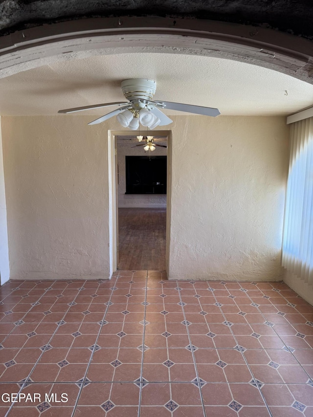 interior space featuring beam ceiling, a textured ceiling, and ceiling fan