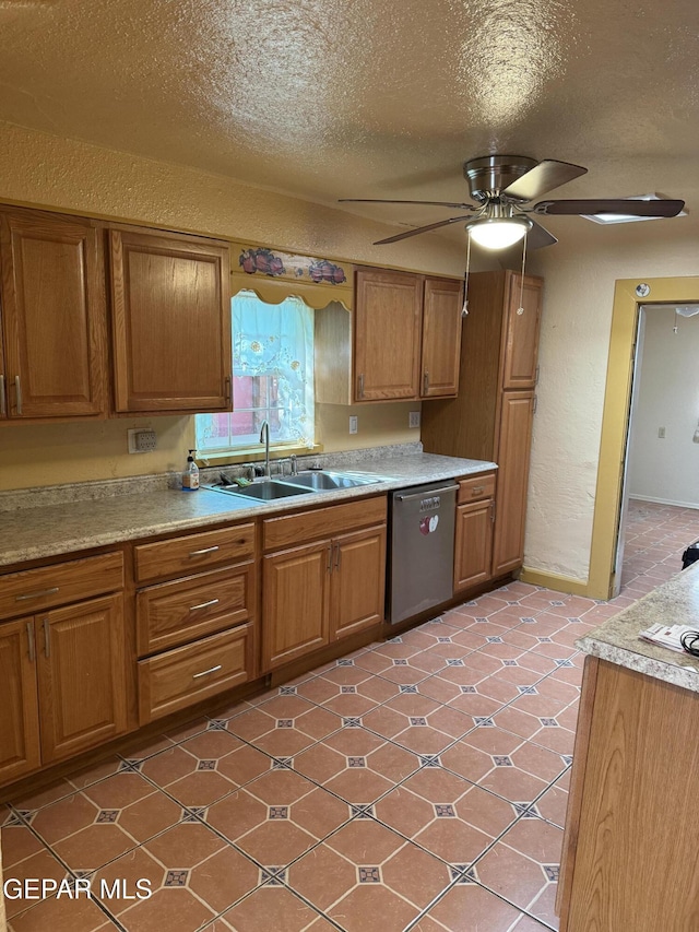 kitchen featuring stainless steel dishwasher, ceiling fan, sink, and a textured ceiling