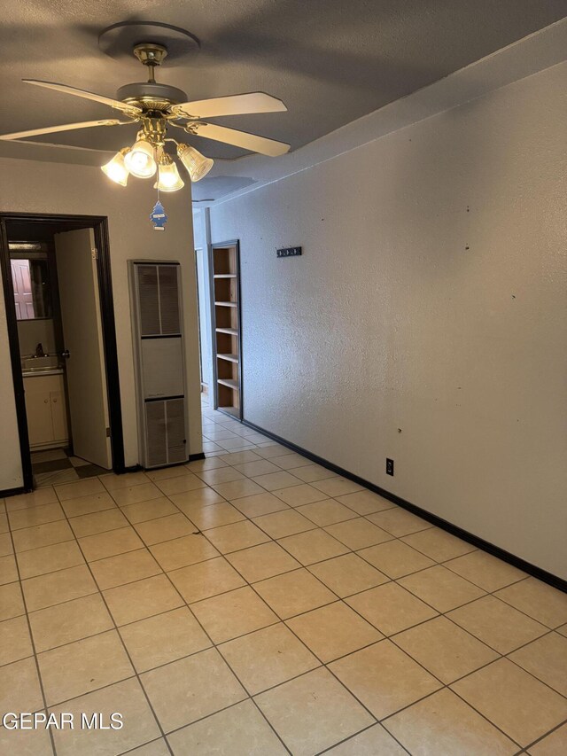 tiled spare room featuring ceiling fan