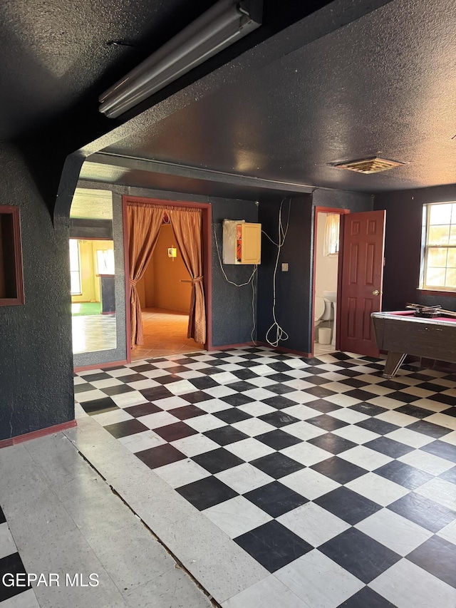 interior space with a textured ceiling and billiards