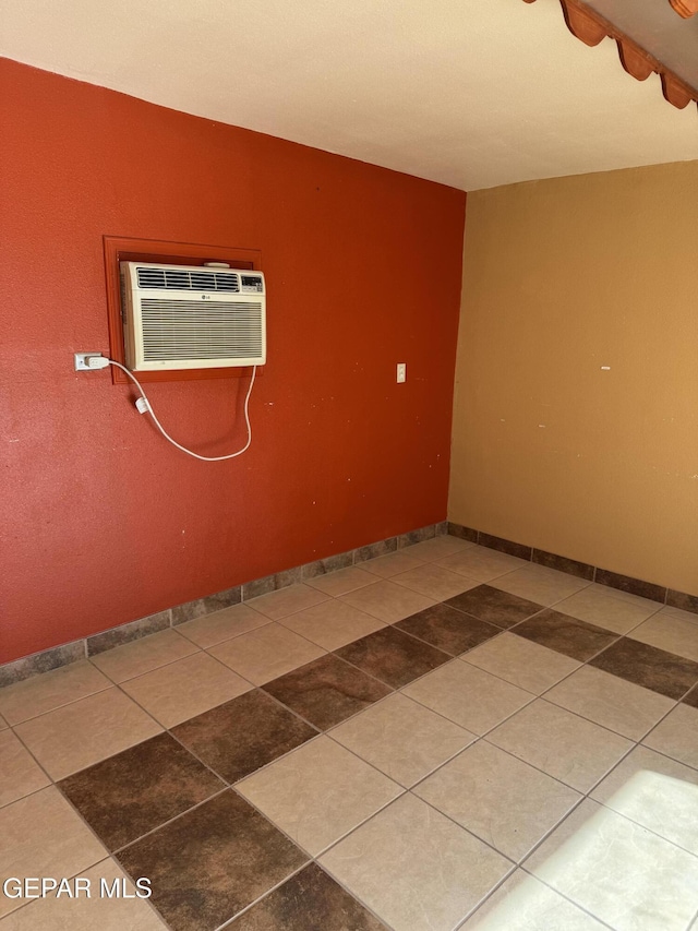 empty room featuring a wall mounted air conditioner and tile patterned floors