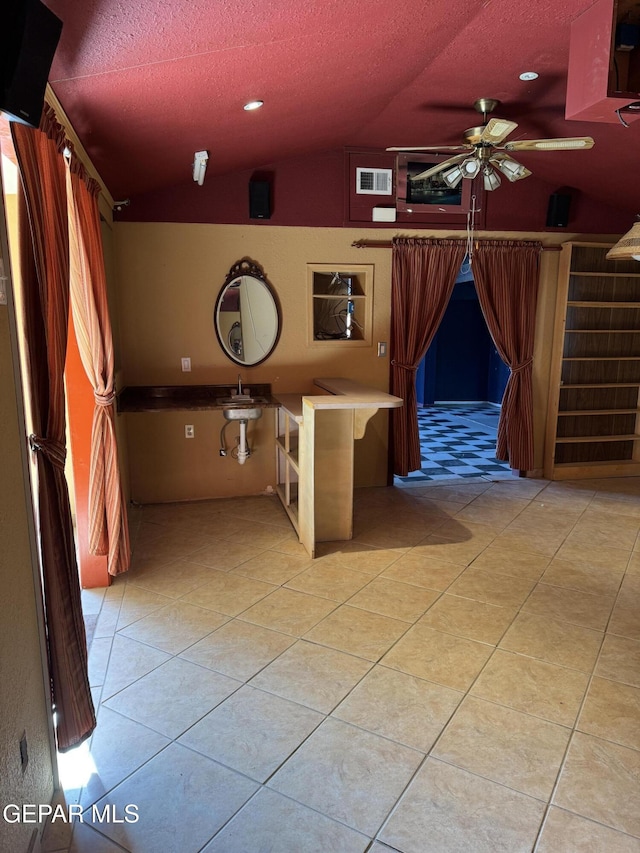 interior space with a textured ceiling, ceiling fan, and lofted ceiling