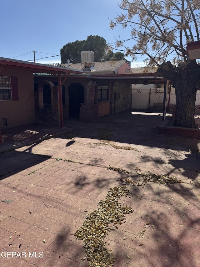 rear view of property featuring cooling unit and a carport