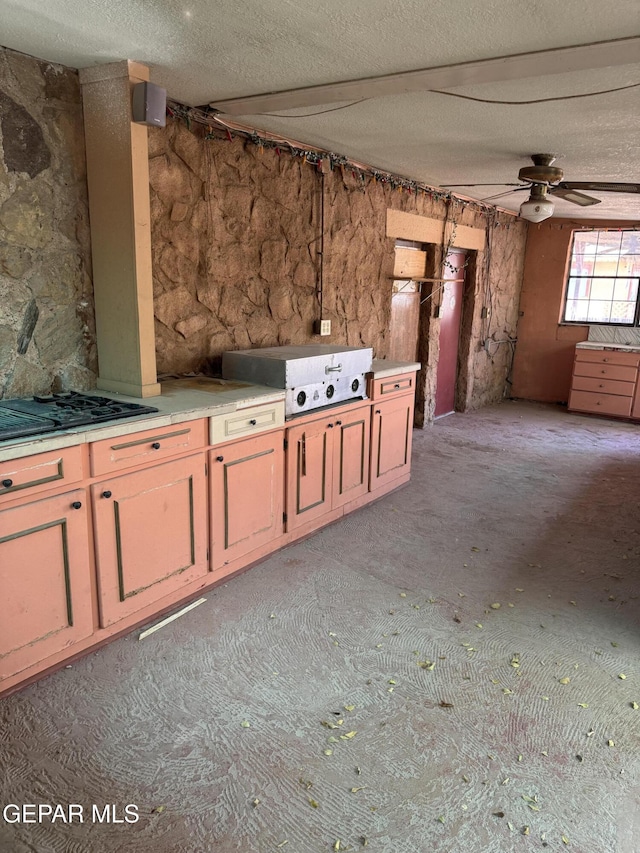 kitchen featuring ceiling fan and a textured ceiling