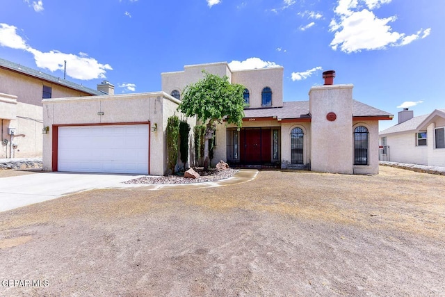 pueblo-style house featuring a garage