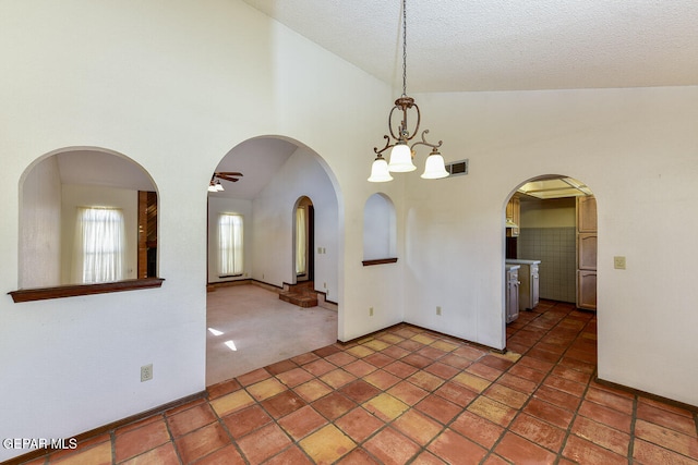 interior space featuring high vaulted ceiling, an inviting chandelier, carpet floors, and a textured ceiling