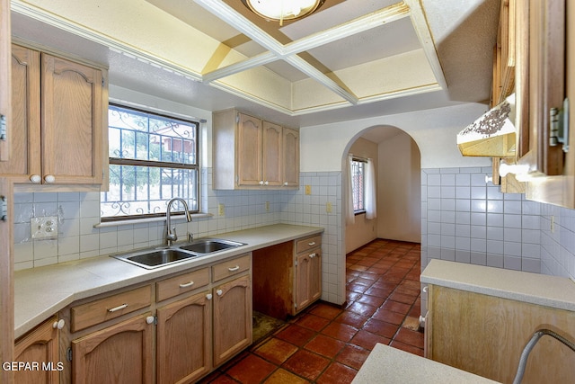 kitchen featuring sink, dark tile patterned floors, tile walls, and tasteful backsplash