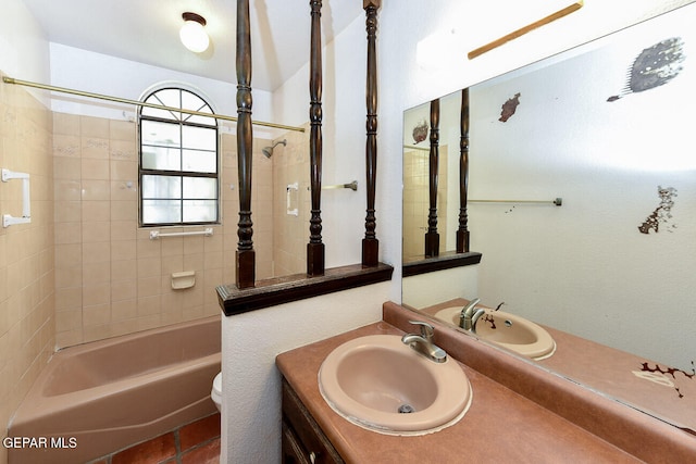 full bathroom featuring vanity, tiled shower / bath combo, and toilet