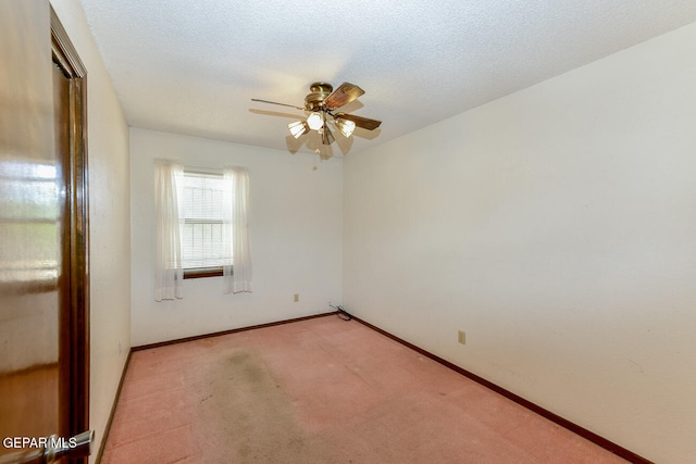 spare room featuring a textured ceiling, light colored carpet, and ceiling fan