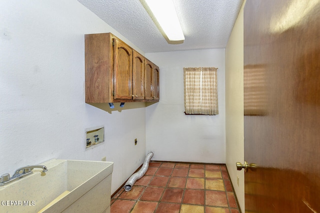 clothes washing area featuring washer hookup, a textured ceiling, cabinets, sink, and electric dryer hookup