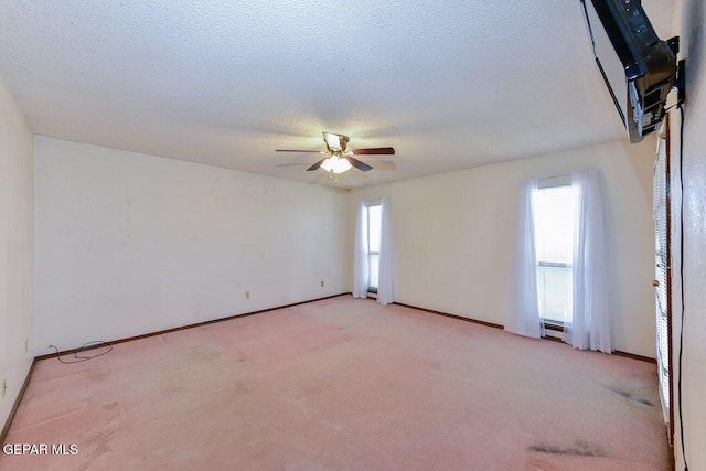 spare room with a textured ceiling, light carpet, and ceiling fan