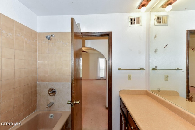 bathroom with vanity and tiled shower / bath