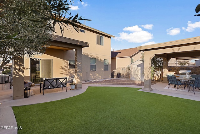 rear view of property featuring a patio area and a lawn