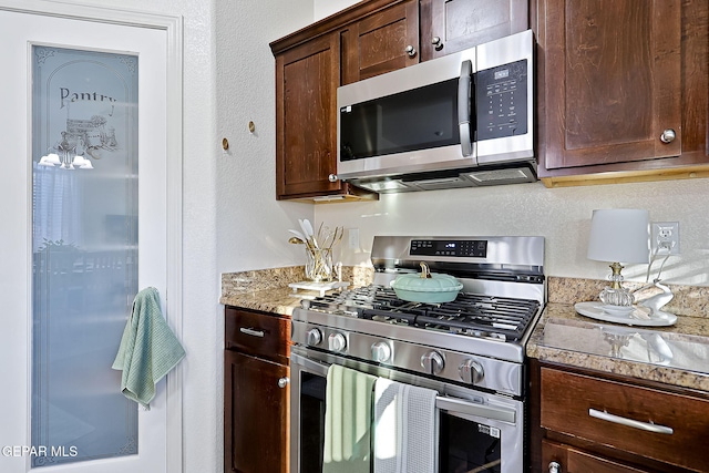 kitchen featuring dark brown cabinets and appliances with stainless steel finishes