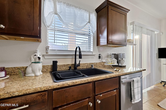 kitchen featuring stainless steel dishwasher, dark brown cabinets, sink, and light tile patterned floors