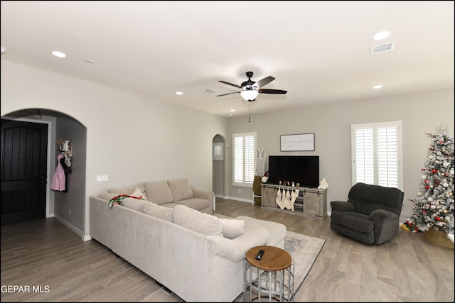 living room with ceiling fan, a healthy amount of sunlight, and light wood-type flooring