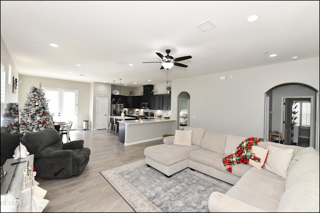 living room with ceiling fan and light wood-type flooring