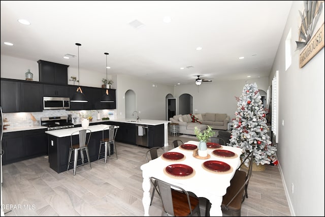 dining room with ceiling fan, sink, and light hardwood / wood-style floors