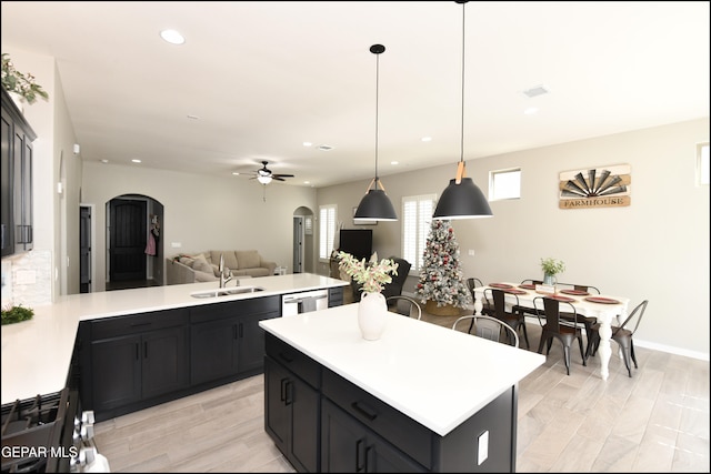 kitchen featuring dishwasher, sink, light hardwood / wood-style flooring, ceiling fan, and decorative light fixtures