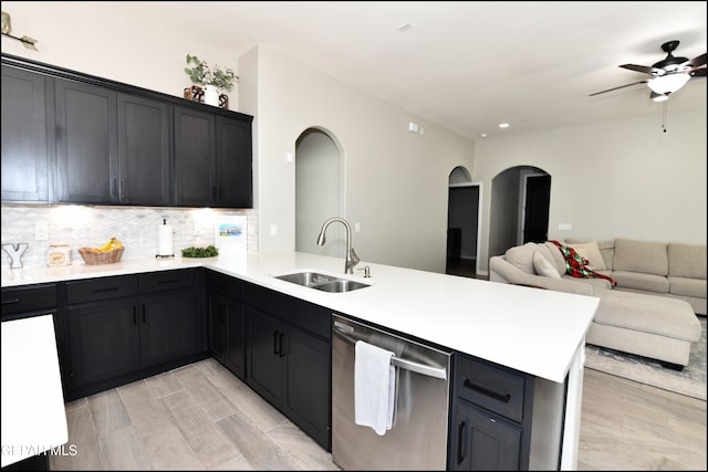 kitchen featuring dishwasher, decorative backsplash, kitchen peninsula, and sink