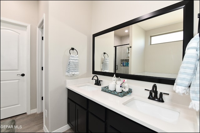 bathroom with hardwood / wood-style flooring, vanity, and an enclosed shower