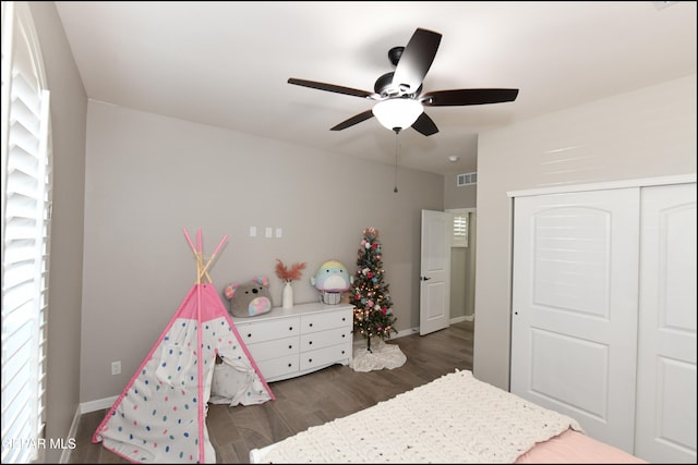 bedroom featuring dark hardwood / wood-style flooring, ceiling fan, and a closet