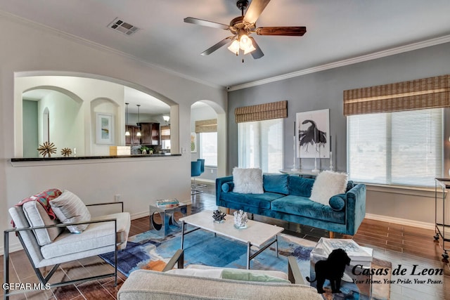 living room featuring hardwood / wood-style flooring, ceiling fan, and crown molding