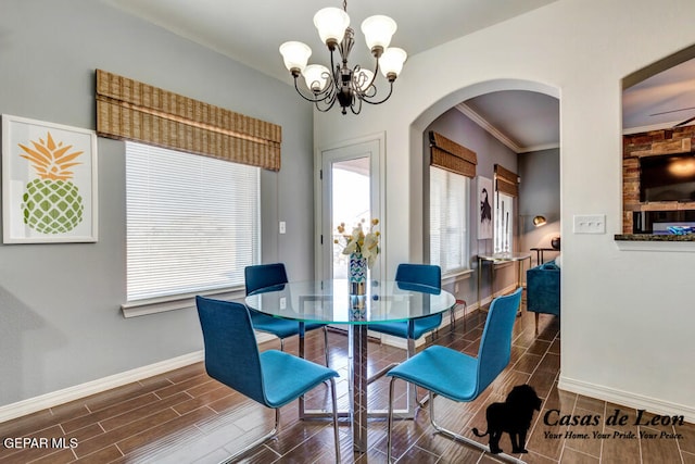 dining room featuring dark hardwood / wood-style floors, ceiling fan with notable chandelier, and crown molding