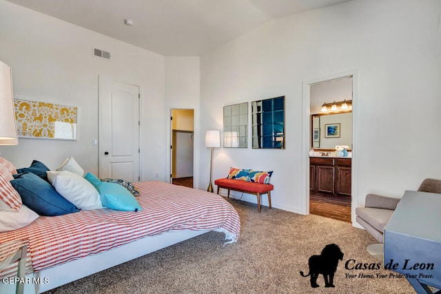 carpeted bedroom with connected bathroom, a closet, and lofted ceiling