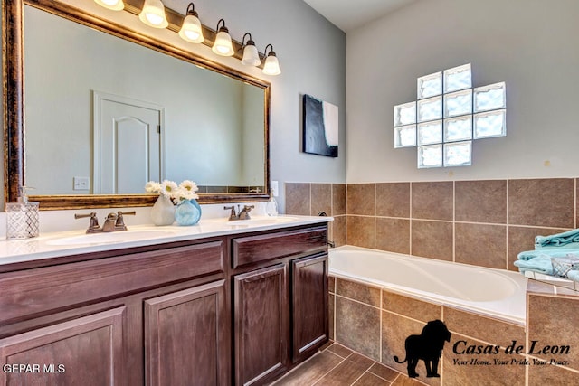 bathroom featuring vanity and tiled tub