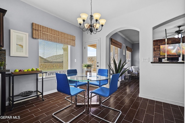 dining space featuring baseboards, a healthy amount of sunlight, a chandelier, wood finish floors, and arched walkways