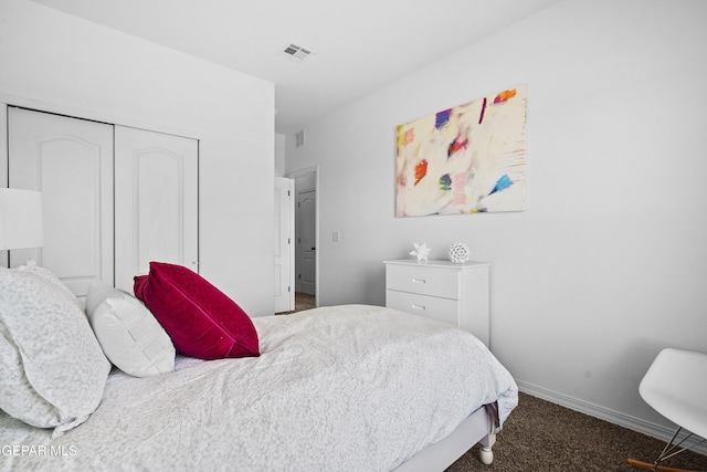 carpeted bedroom featuring baseboards, a closet, and visible vents